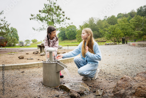 Wallpaper Mural Sisters washing hands from fountain at park Torontodigital.ca