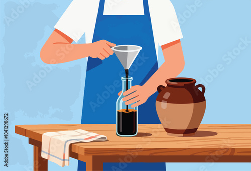 Person in apron pouring dark liquid from funnel into bottle next to jug