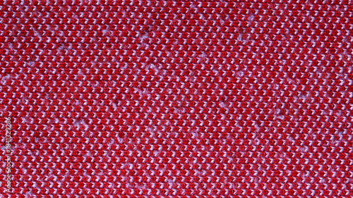Close-up (macro) texture of a red and white knitted fabric. Melange diagonal striped pattern, an ideal background for apparel design, winter, or festive projects.