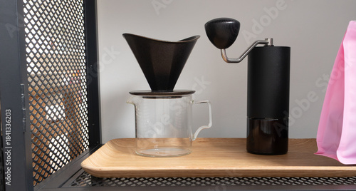 Coffee dripper, grinder and glass server on bamboo tray. Alternative coffee brewing set  in banner format