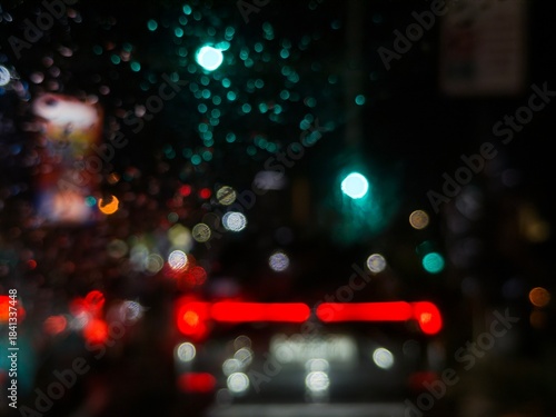 Blur photo of vehicle lights and billboards during rain. Car windows fog up when it rains at night. Abstract lights in the dark background