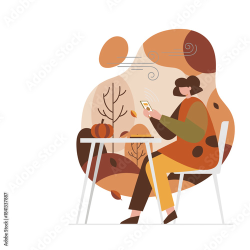 Woman uses smartphone at outdoor cafe table enjoying the windy autumn fall season