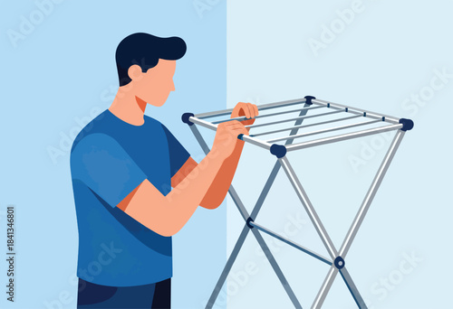 Man folding a collapsible clothes drying rack