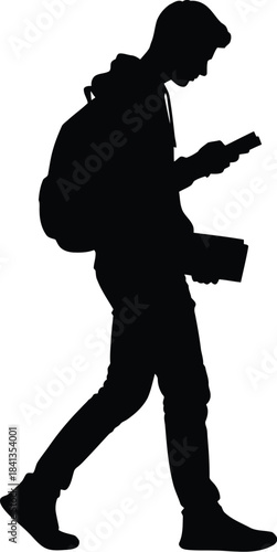 Silhouette of a student walking while looking at a smartphone and holding books