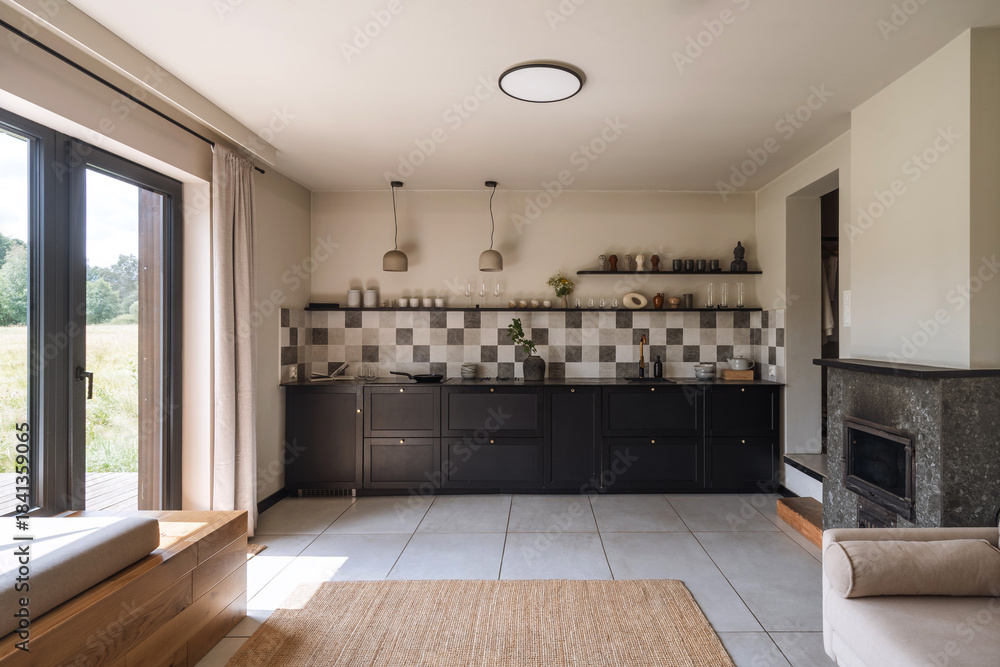 Obraz premium Modern kitchen design with black accents and natural light in a spacious apartment