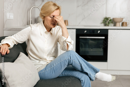 Feeling overwhelmed with a headache in a modern living room setting