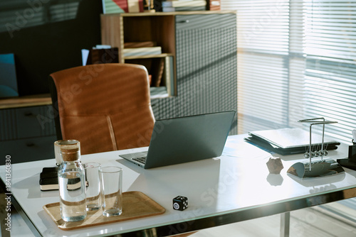 Vászonkép Modern office workspace featuring closed laptop, glasses of water, coffee cup, d