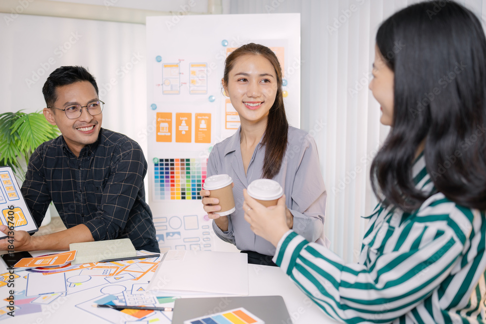 Obraz premium UX/UI designers presenting their final design project to the team, showcasing app interface screens and explaining user experience strategies in a professional creative office environment.