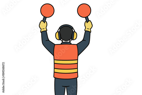 Airport ground crew member signaling with two orange paddles and wearing safety gear