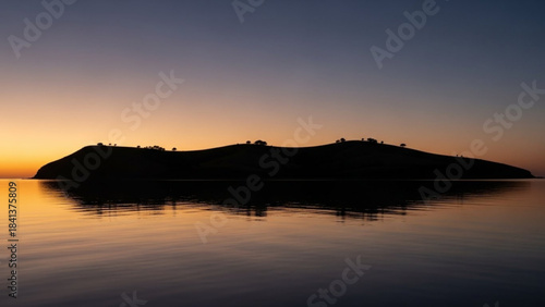 Silhouette of a small island on the water at sunset or sunrise