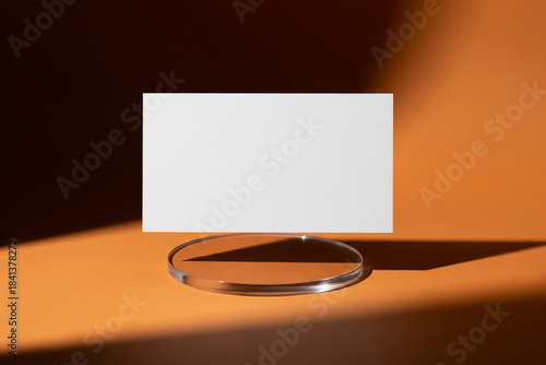 Minimalist Business Card Mockup on Acrylic Stand with Harsh Lighting and Warm Orange Background