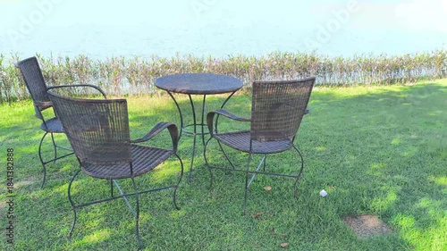 wicker rattan chair table for resting on terrace at waterside of pond lake