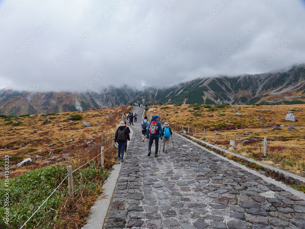 Obraz premium 秋の観光名所立山黒部アルペンルートの室堂山頂で歩く観光客の姿と山の風景