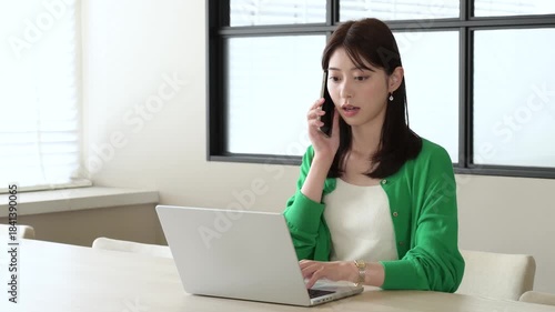 オフィスでスマホで通話をする日本人女性