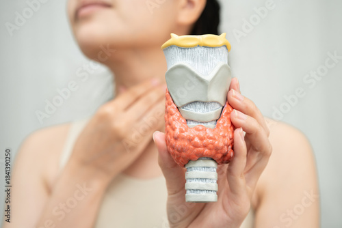 Hyperthyroidism, Overactive Thyroid, Thyroid Lymphoma, Asian woman with thyroid gland human anatomy model.