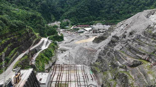 Aerial drone shot of heavy civil engineering work at the Arun III hydroelectric dam site in Nepal, featuring massive concrete foundations and rebar reinforcement grids for green energy