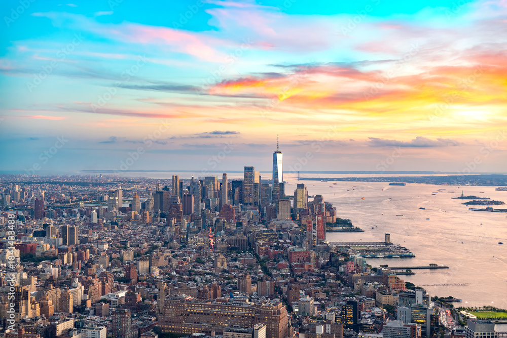 Obraz premium A spectacular, elevated panoramic view of the Downtown Manhattan skyline and surrounding boroughs under a vibrant sunset sky.