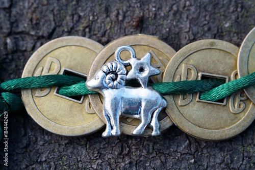Chinese coins and aries figurine in close-up. Finance and horoscope.