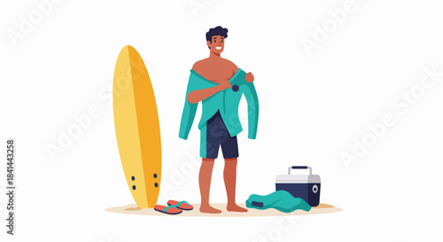Happy young man preparing for a surf session, changing into his wetsuit on the beach next to his surfboard and cooler.