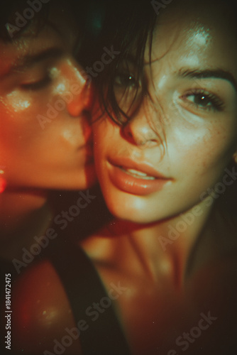 A Polaroid selfie of a young couple. The guy kisses the smiling girl on the cheek.