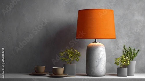 Orange lampshade on marble base; plants and cups on shelf against gray wall
