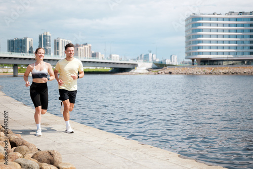 People jogging by the river in a city setting
