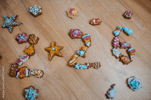 Number and shapes made of decorated cookies on a wooden floor at a gathering