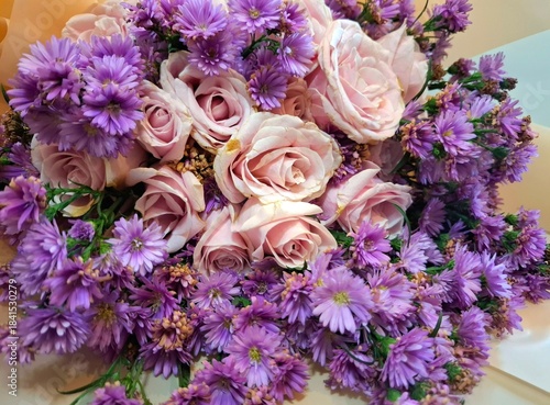Close-up photo of beautiful flower bouquet of pink roses and purple chrysanthemum.