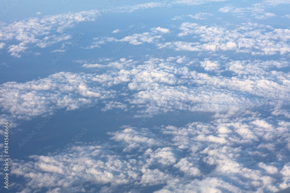 Fototapeta premium Aircraft window view of fluffy white clouds over Romania, Europe. Aerial view cloudscape.