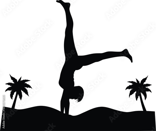 A person performs a handstand on a sandy beach between two tropical palm trees