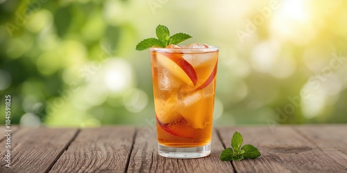 Fruit iced tea with peaches and apples in a glass on a table, natural fruit flavors for a cooled drink