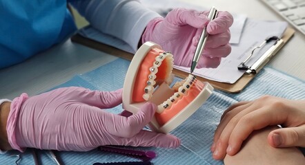Fotobehang Tandarts Beugel demonstratie tijdens orthodontisch consult  © Nadzeya