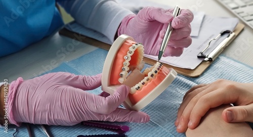 Demonstration of dental braces on a model during an orthodontic consultation