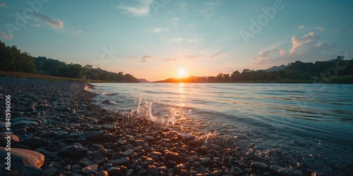 Fototapeta Naklejka Na Ścianę i Meble -  Pebble-strewn river shoreline with smooth stones, ideal for shoreline activities and scenic views