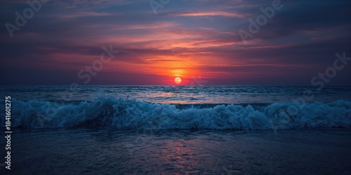 Vibrant ocean sunset with a colorful sky and a rolling wave approaching the sandy shore, illuminated by the rising full moon, seasonal change