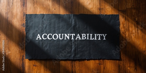 Accountability word written on black paper with wooden background, used for motivational or organizational signage