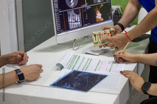 Dental professional discussing implant treatment plan with patient