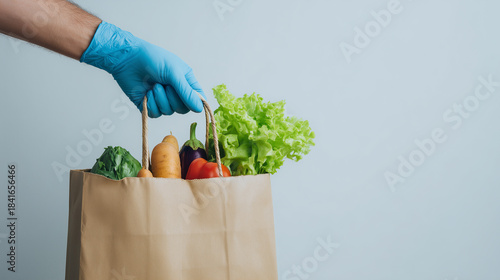 Careful handoff: gloved hand places fresh produce into a paper bag