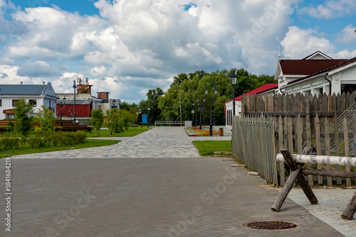 Fototapeta Naklejka Na Ścianę i Meble -  A street in a recreation park in a small Siberian town, bathed in autumn sunshine. Tourism in Russia