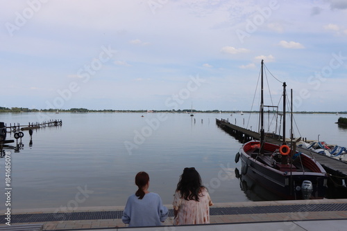 Zwei Frauen genießen den Blick über den Dümmer See in Dümmerlohhausen bei ruhiger Abendstimmung- Dümmer See, Niedersachsen, Deutschland