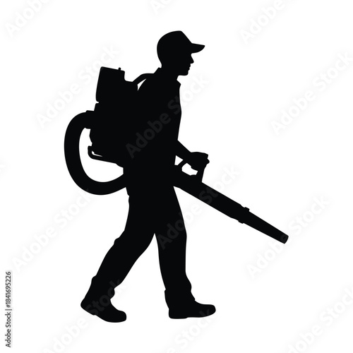 Silhouette of a worker using a leaf blower outdoors