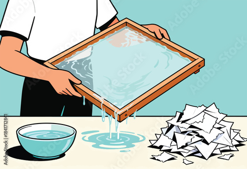 Person making paper using a screen and water with shredded paper nearby