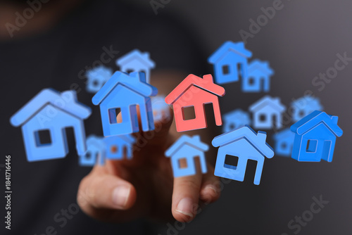A hand selecting a house ic...