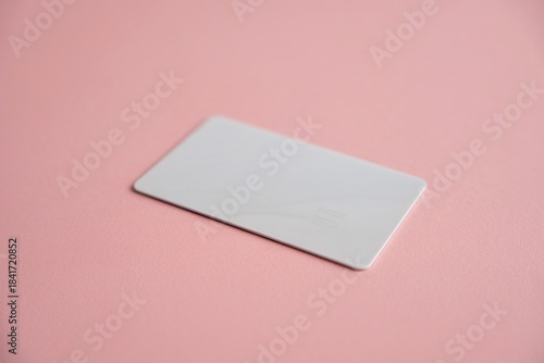 Blank white credit card mockup floating on a subtle pink background with modern shadow overlay, ideal for banking, financial technology, and premium retail advertising.