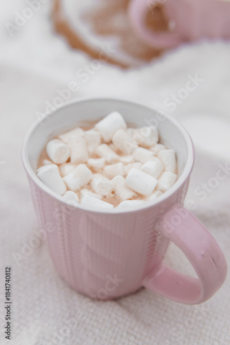 Pink mug with hot cocoa and white marshmallow. Cozy winter drink for Christmas holiday. Warm beverage with sweet treat.