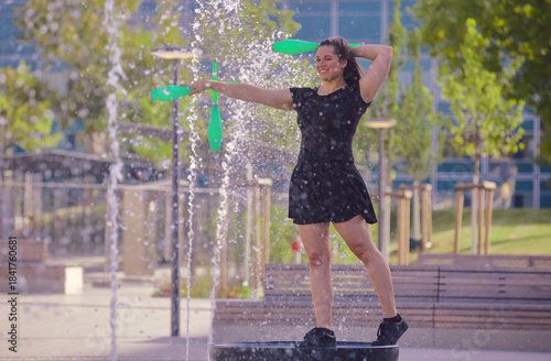 Eine junge Frau mit Keulen an einem Wasserspiel