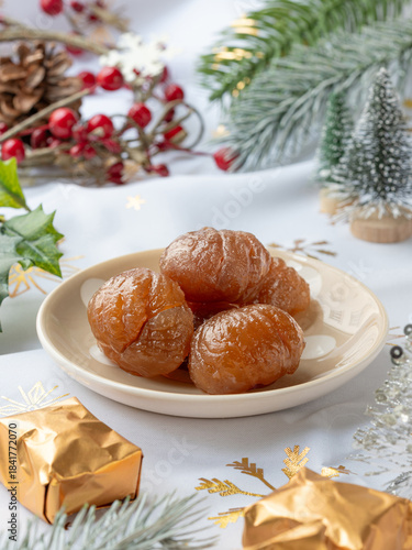 A plate of  French tradition candied chestnut or marron glacé with festive decoration and Christmas atmosphere.