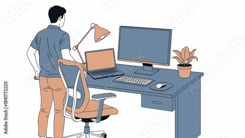 A man standing in front of his desk with a computer, laptop, lamp and chair