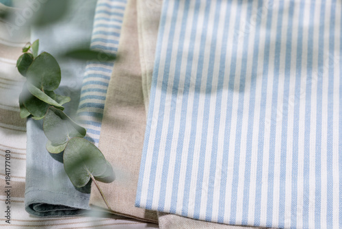 Striped Cotton Napkins On Linen Tablecloth With Eucalyptus Branch And Soft Natural Light. Perfect For Eco-Friendly Kitchen Designs, Home Decor Mockups, Or Sustainable Lifestyle Visual Content