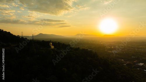 Aerial view at sunset above the Mekong river in Laos revealing Pakse city golden giant buddha